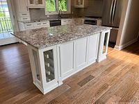 Front and side view showing granite top, panelled sides, glass wine cabinet