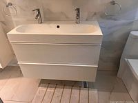 Front view showing entire vanity, double faucets, drawers