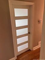 Full view of white door with four frosted glass panels and trim