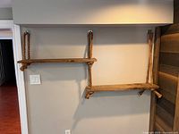 Front view showing both wooden shelves suspended from ropes and attached to wall