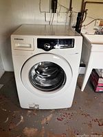 Front view of Samsung front-load washer showing door, controls, and detergent drawer