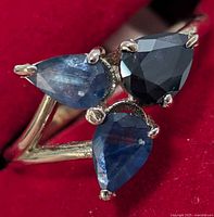 Front view showing three pear sapphires and gold band