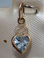 Close-up of pendant front showing heart blue topaz and gold setting