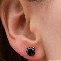 Earring worn on ear showing size, black diamond in four-prong white gold setting