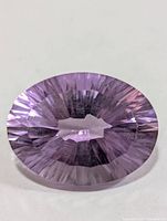 Front view of faceted oval amethyst showing radial facets and color