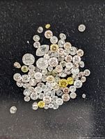 Close view of assorted loose diamonds on black surface