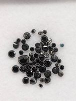 Close-up of parcel showing numerous round black diamonds and one blue stone