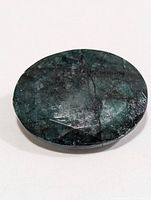 Front view of dark green oval emerald