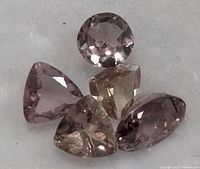 Close-up of five colour-change garnets showing faceting and hue variation
