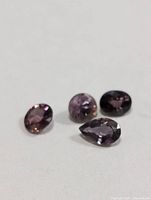 Four faceted color-changing sapphires on white background