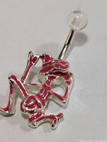 Front view of silver belly button ring showing pink enamel kneeling figure charm and clear top ball