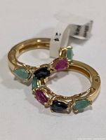 two hinged hoop earrings showing gemstone arrangement