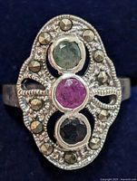 Front view of ring showing emerald, ruby, sapphire cabochons and marcasite border