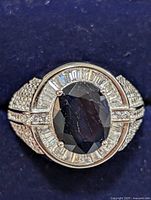 Top view showing oval sapphire, baguette halo, pavé shoulders