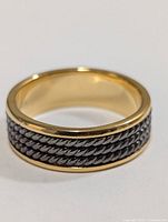 Ring showing gold-tone edges and rope-style silver center band