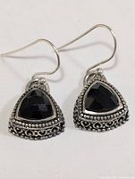 Front view of both earrings showing onyx stones and filigree detailing