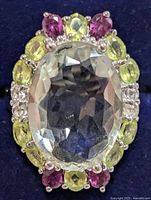 Front view of ring showing central green amethyst and surrounding gemstones