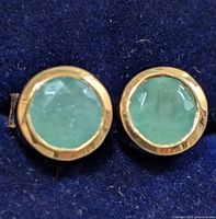 Front view showing emerald stones and bezel setting
