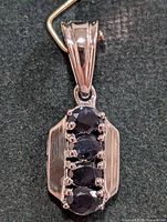 Front view of silver pendant with four sapphires