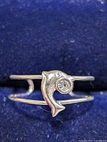 Front view of silver-tone toe ring showing dolphin motif and clear stone