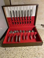 Flatware set displayed in open wooden case showing all pieces