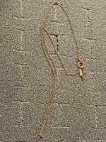 Full view of gold curb chain necklace laid flat