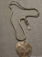 Full view of necklace showing snake chain, pendant and clasp