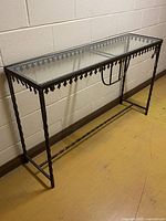 Full view of iron console table with glass top