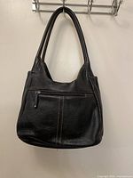 Front view of black pebbled leather Danier shoulder bag with dual handles and front zip pocket