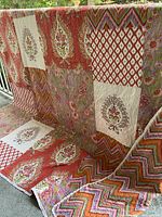 Quilt draped over railing showing full patchwork design, patterns and colors