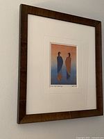 Framed print on wall showing wood frame and matting
