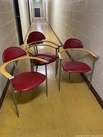 Four red leather Arrben armchairs positioned in hallway