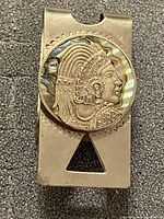 Front view of money clip showing engraved warrior medallion and abalone ring