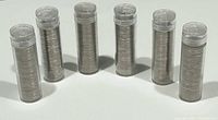Six tubes of stacked coins standing upright
