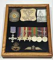 Overall framed display showing medals, badges, patch and photograph