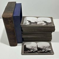 Stack of stereoview cards beside slipcase