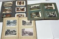 Three open albums showing assorted postcards mounted inside