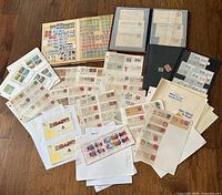 overview of entire lot showing albums, loose stamp pages and postcards spread on floor