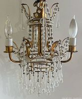 Full view of brass chandelier with crystals hanging
