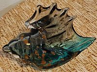 Overall view of glass seashell showing color gradient and gold flecks