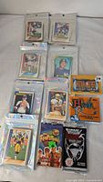 Overall lot showing six zip sleeves of sports cards and four sealed packs