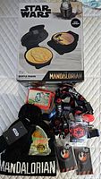 Lot overview showing waffle maker box, hat & gloves, lanyards, trading card