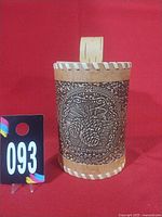 Front view showing decorative pine-cone motif and size reference