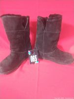 Pair of dark brown suede boots side view with lot tag visible