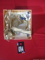 Angled view of gift box with cup and spoon tied with ribbon
