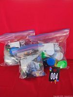 Three zipper bags containing colourful arcade pushbuttons displayed together