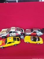 Four cars including white No.5, silver 924, yellow coupe, yellow roadster