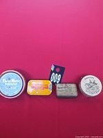 Group shot of four tins on red background