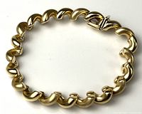 Full view of curved-link yellow gold bracelet in closed loop