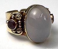 Three-quarter view showing moonstone cabochon and ruby on ornate shoulder